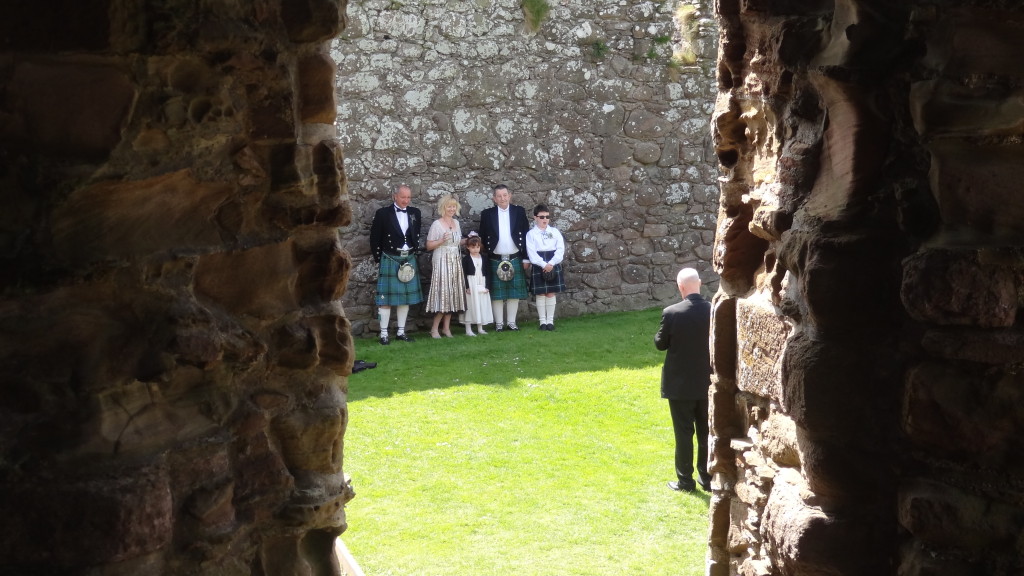 Family dressed in kilt posing for a wedding photographer