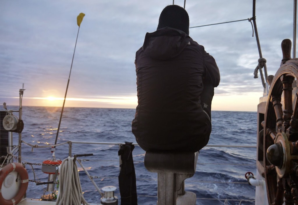 Sitting at the helm of a sailboat, getting lost in the ocean